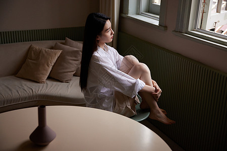 成熟女性坐在家中客厅发呆思考图片素材