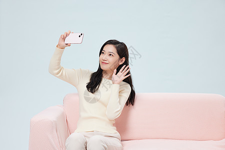 女性在家使用手机自拍图片