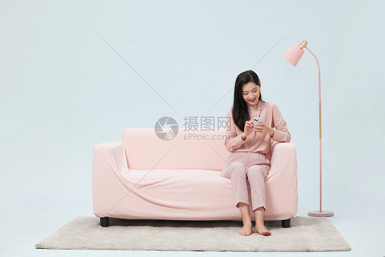 女性假期在家悠闲玩手机图片