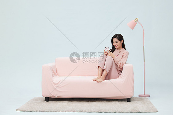 女性假期在家悠闲玩手机图片