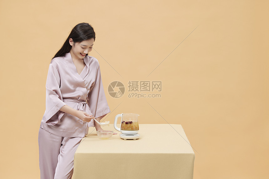 女性假期在家使用养生壶制作早餐图片