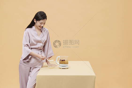 女性假期在家使用养生壶制作早餐图片