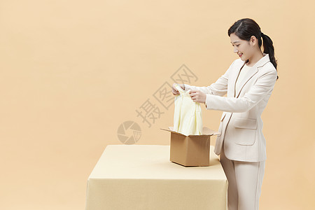 商务女性打开包裹查看商品图片