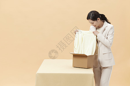 商务女性打开包裹查看商品图片