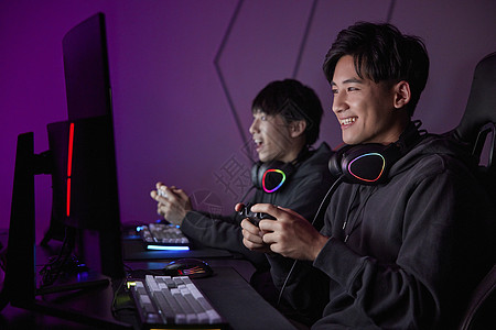 青年男性熬夜通宵使用手柄玩电脑游戏图片素材