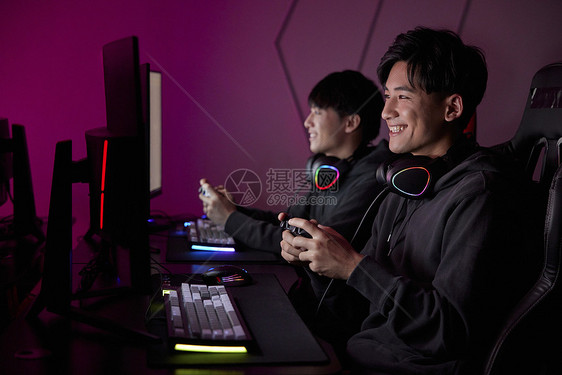 青年男性熬夜通宵使用手柄玩电脑游戏图片