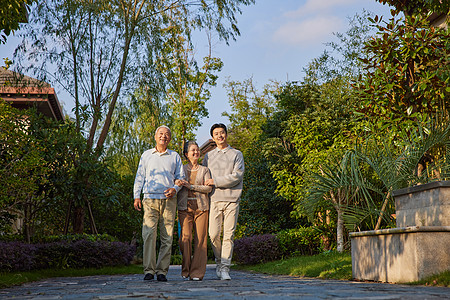 年轻男性陪着父母户外散步图片素材