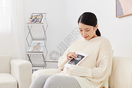坐沙发上的人孕期妈妈居家坐沙发上看婴儿B超图像背景