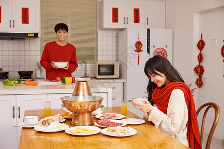年轻情侣居家吃火锅过新年图片