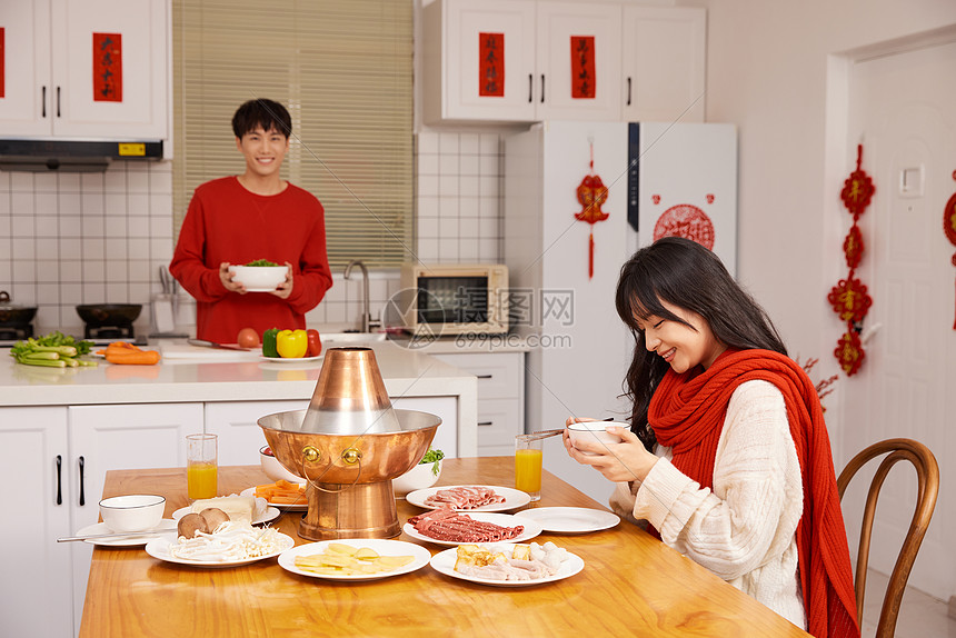 年轻情侣居家吃火锅过新年图片