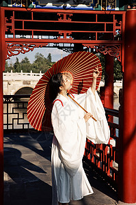 夕阳下在桥廊上撑伞的古风美女图片