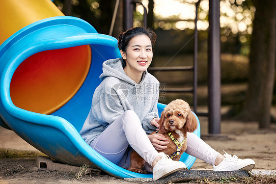 在公园里和泰迪一起玩耍的运动少女图片