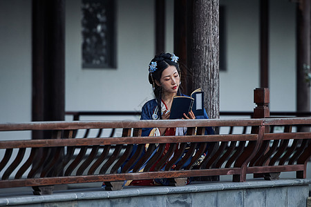 国风潮流拿着古书边走边看的古风汉服美女背景