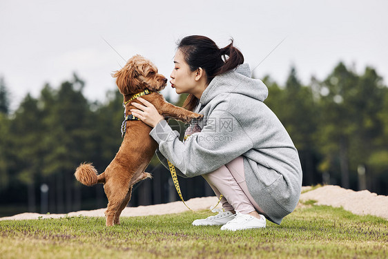 在公园里和泰迪一起玩耍的运动少女图片