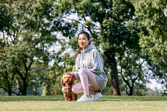 在公园里和泰迪一起玩耍的运动少女图片