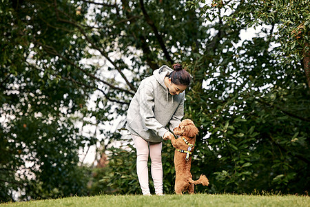 在公园里和泰迪一起玩耍的运动少女图片