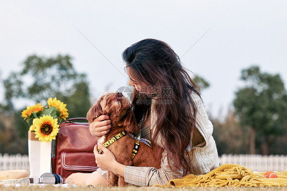美女与小狗在草地上互动图片