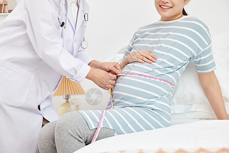 妇产科医生为孕妇测量孕肚特写背景图片