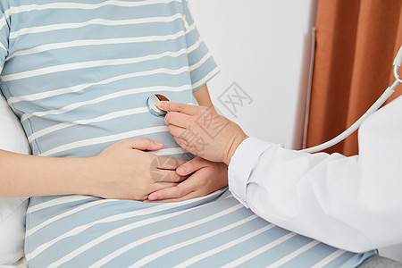 女性生育妇产科医生拿听诊器为孕妇体检特写背景