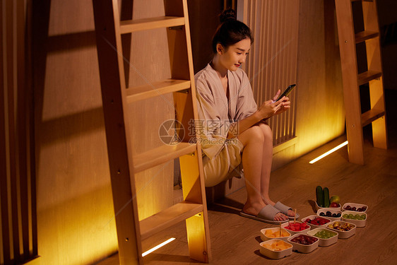 青年女性放松休息吃水果玩手机图片