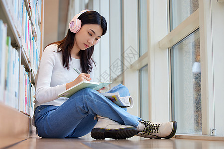 女学生在图书馆看书听音乐图片