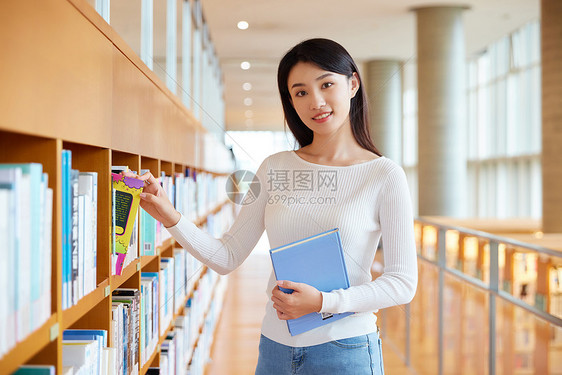 女学生在图书馆书架前挑选书籍图片