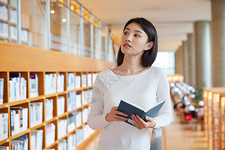 在图书馆翻阅书籍的女大学生图片