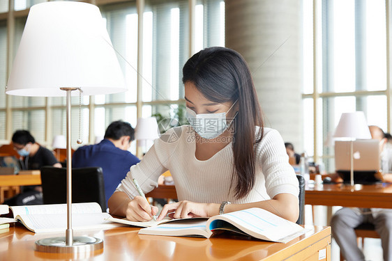 戴口罩的女学生在自习室学习图片