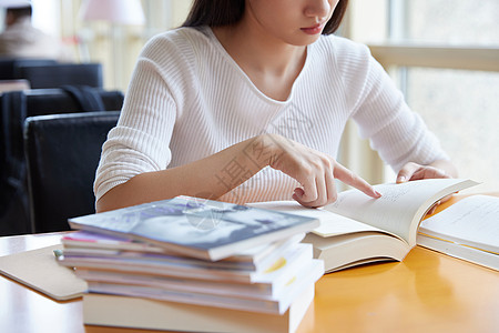 在图书馆看书青年女性在自习室学习看书特写背景