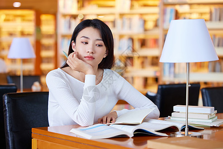 青年女学生图书馆自习开小差高清图片