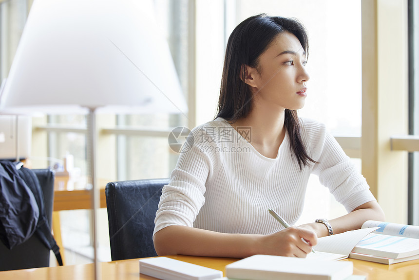 青年女性在自习室学习备考图片