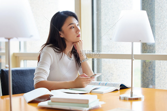 青年女性在图书馆自习室发呆休息图片