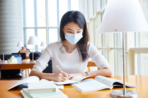 戴口罩的女学生在自习室学习图片