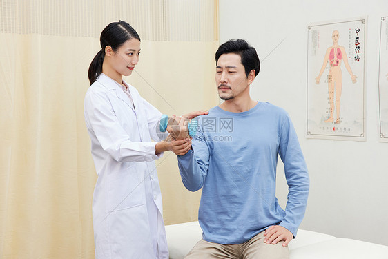 女护士引导男患者举哑铃做手臂复健图片