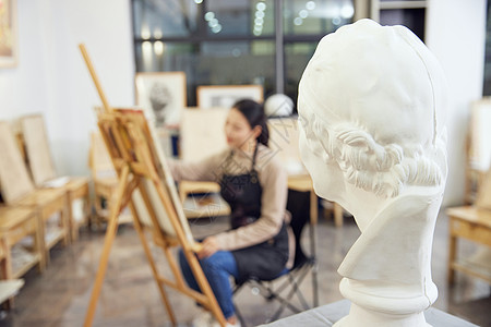 美术班女性坐在画室画石膏像背景