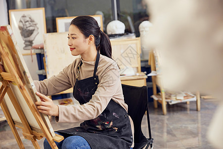 女性坐在画室画石膏像图片