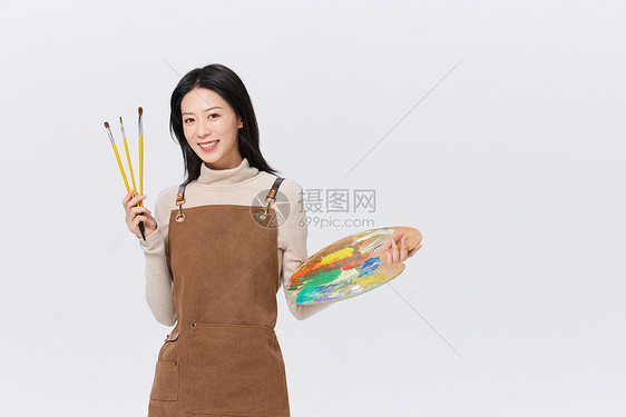 手拿调色盘画画的女性形象图片