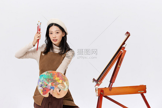 手拿调色盘画画的女性形象图片