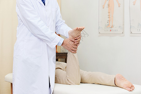 男中医为患者按摩脚部穴位特写背景图片