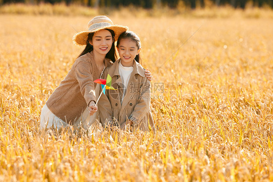 母女二人秋天在稻田里郊游图片