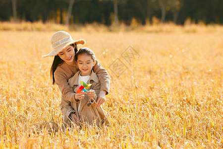 母女二人秋天在稻田里郊游图片