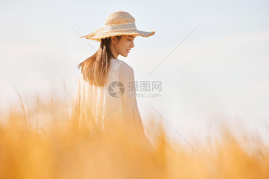 穿着连衣裙走在稻田里的少女图片