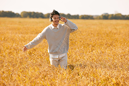 有机农业带着耳机的男性站在稻田里背景