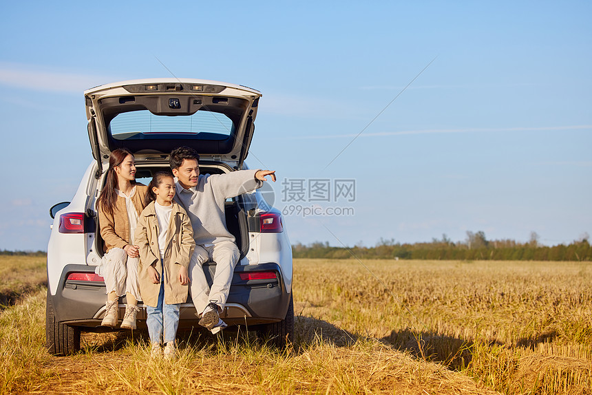 旅行的一家人坐在车厢后图片