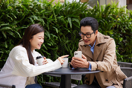 在咖啡店相亲约会的青年男女看手机图片