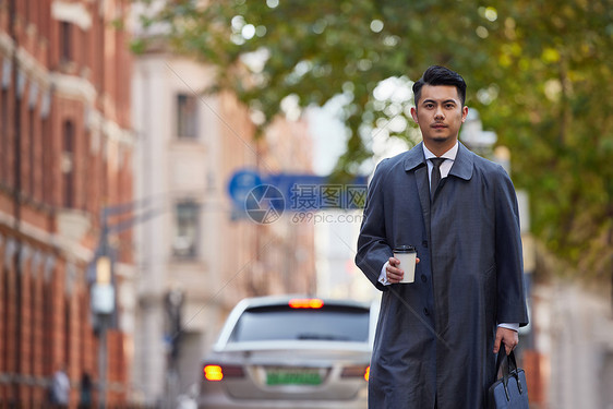 手拿咖啡的都市商务白领男士图片