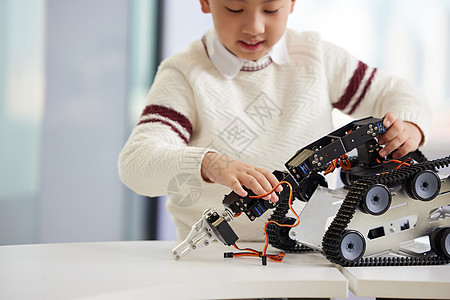机器人教室少儿编程课上实操的小男孩特写背景