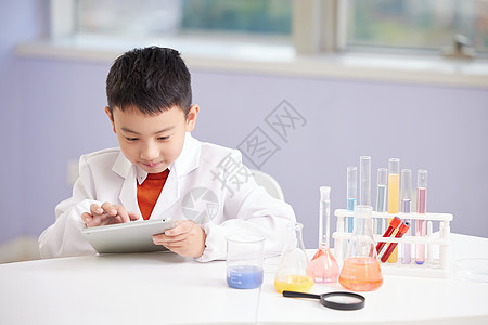 小男孩上兴趣班查看化学资料图片