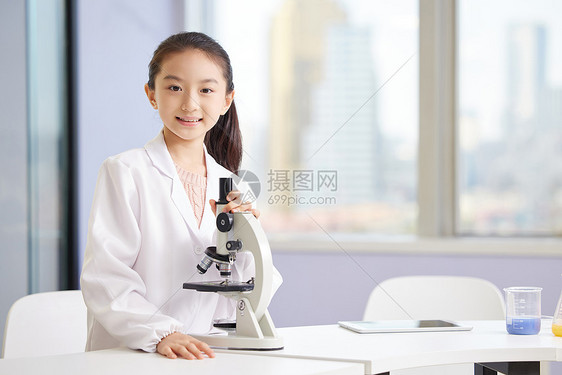 化学兴趣班上使用显微镜的小女孩图片