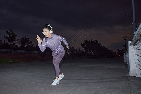 城市夜晚美女江边跑步起步姿势背景